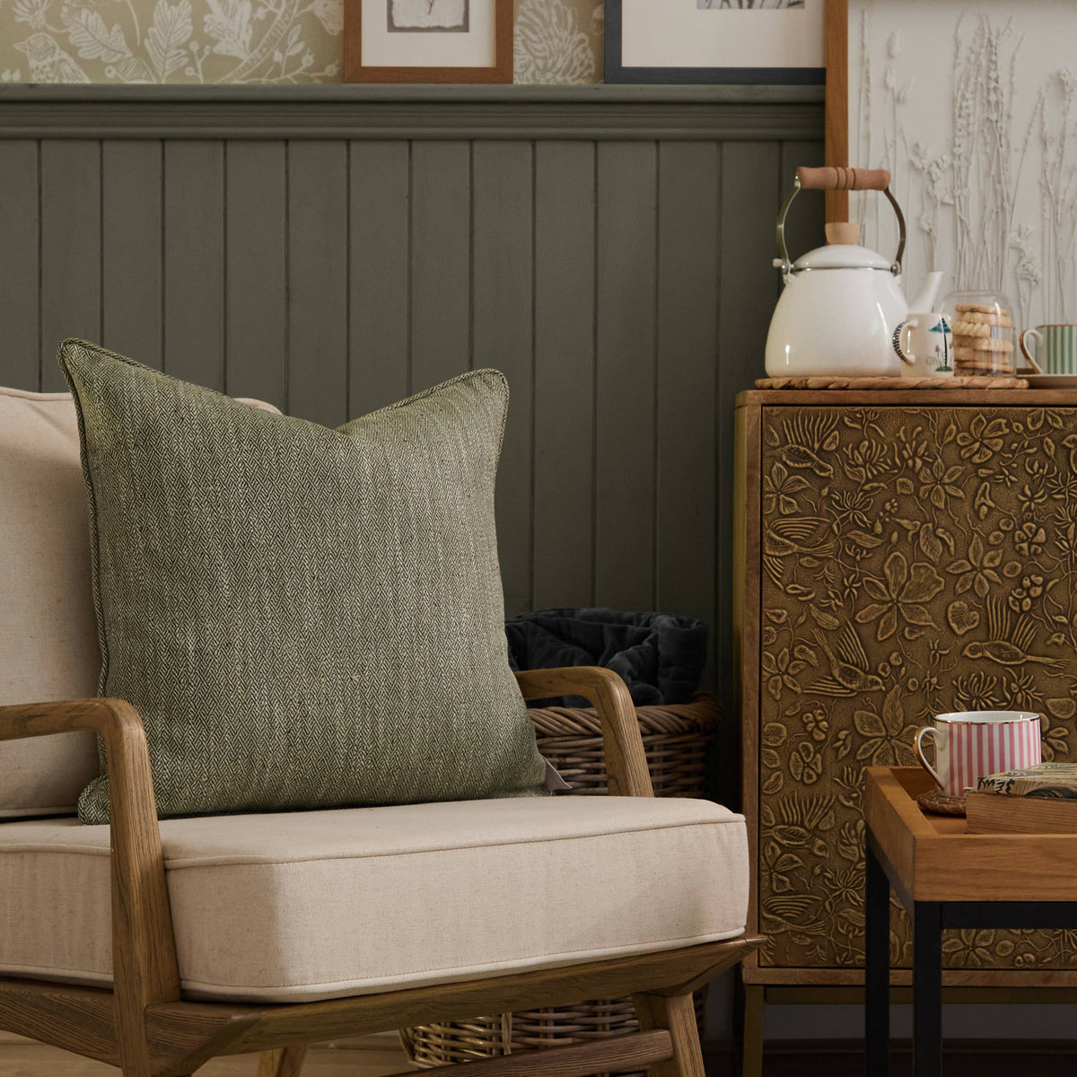 Sofa with a green pillow and decorative items on a wooden sideboard.