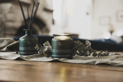 Two candles on a wooden surface with a blurred background