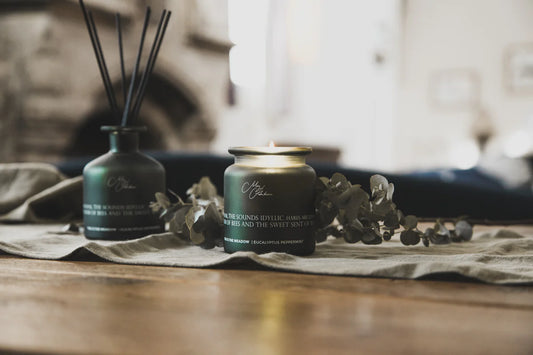 Two candles on a wooden surface with a blurred background