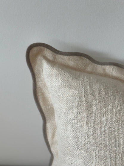 Close-up of a textured beige pillow against a light gray background