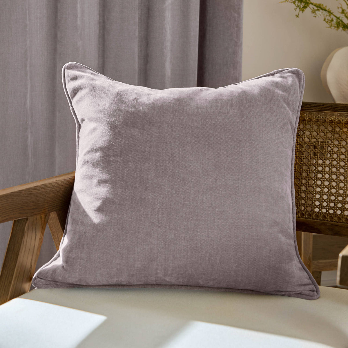 Lilac pillow on a wooden chair with a neutral background