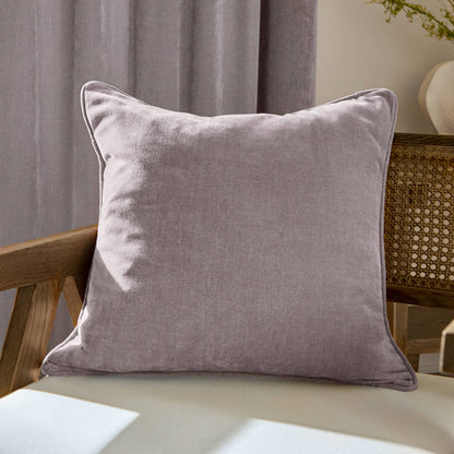 Lilac pillow on a wooden chair with a neutral background